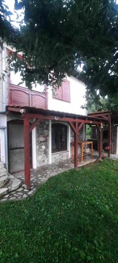 Bočni pogled na kuću s drvenom verandom i travnjakom